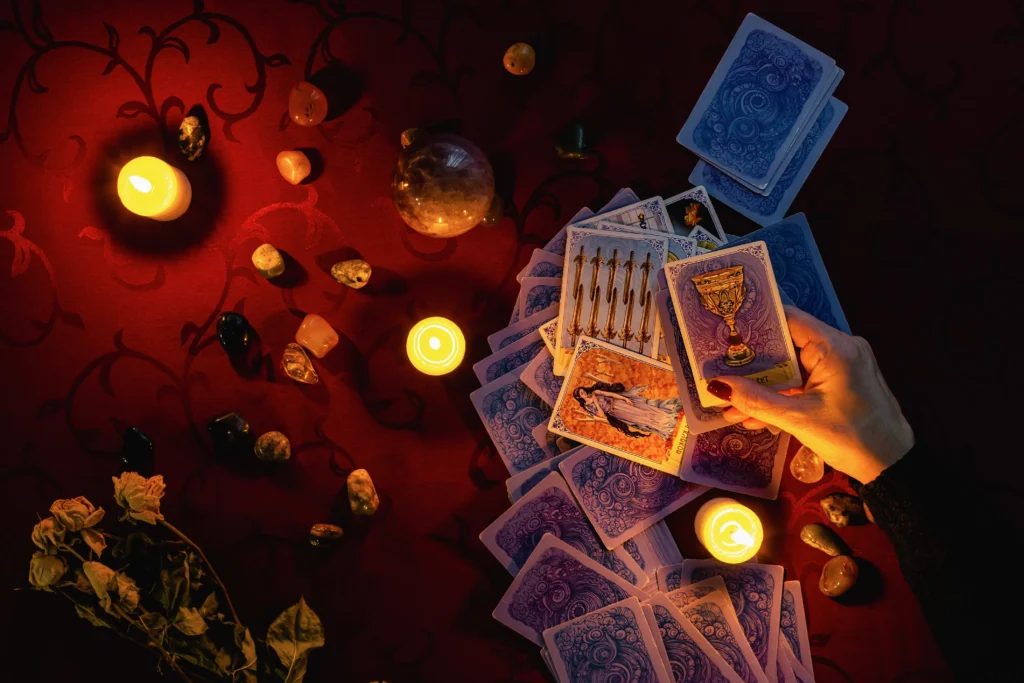 A tarot deck spread on a mystical table with candles and crystals.